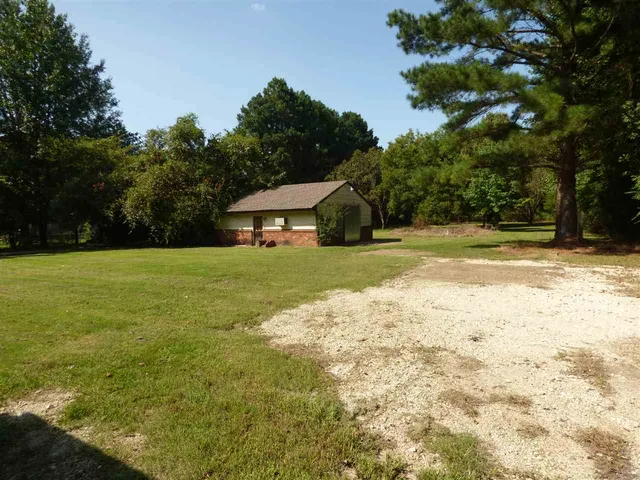 a view of a house with a yard and sitting area