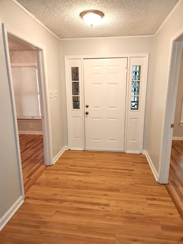 a view of an empty room with wooden floor