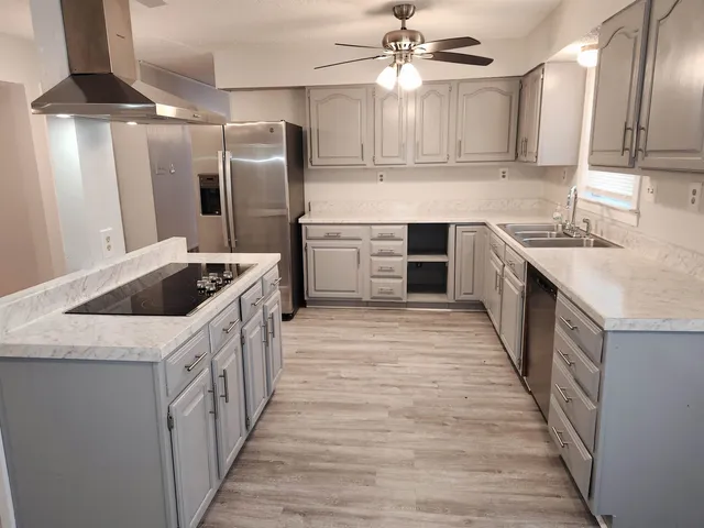 a kitchen with stainless steel appliances granite countertop a sink stove and refrigerator