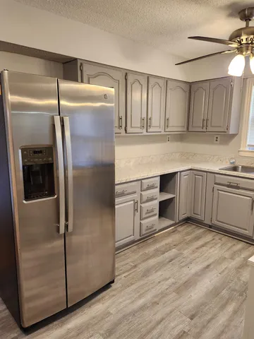 a kitchen with granite countertop a refrigerator and a sink