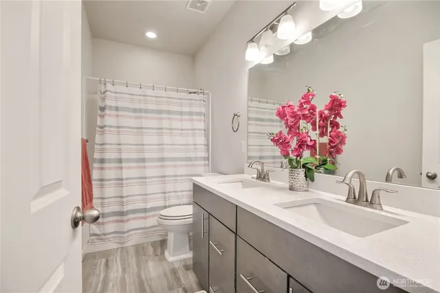 a bathroom with a sink vanity mirror and toilet