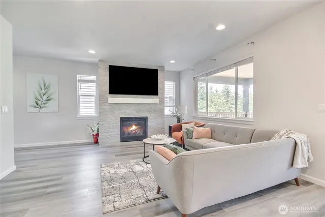 a living room with furniture a fireplace and a flat screen tv