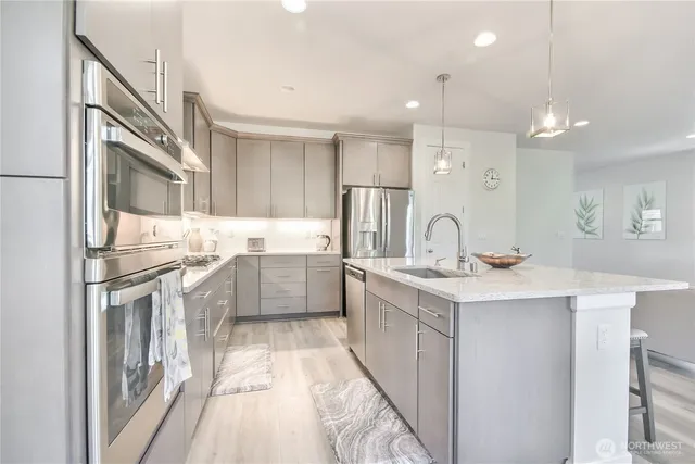a kitchen with stainless steel appliances granite countertop a sink stove and refrigerator