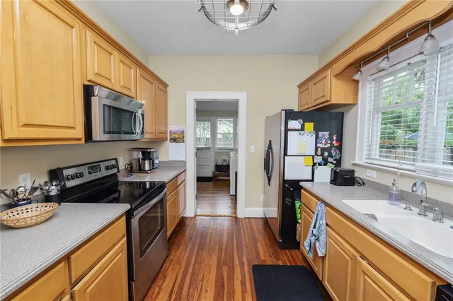 a kitchen with stainless steel appliances granite countertop a stove a sink dishwasher and a microwave oven with wooden floor