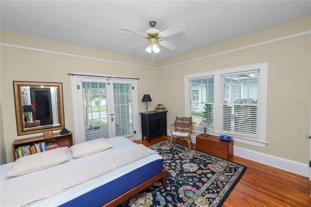 a living room with furniture large window and wooden floor