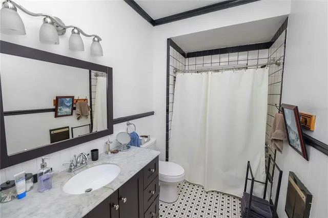 a bathroom with a sink a toilet a mirror and shower curtain