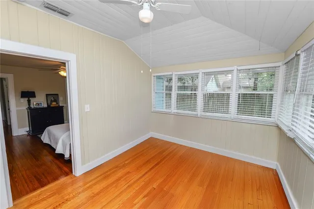a view of a bedroom with wooden floor and a window