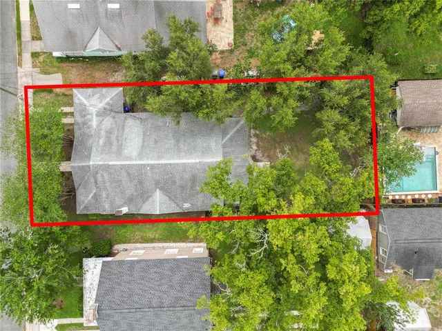 a view of a house with a yard patio and a large tree