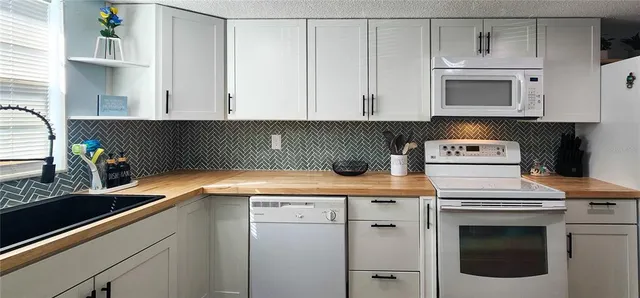 a kitchen with granite countertop stainless steel appliances sink and cabinets