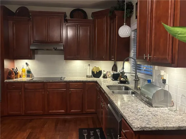 a kitchen with granite countertop stainless steel appliances and wooden cabinets