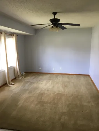 a view of room with a ceiling fan and window