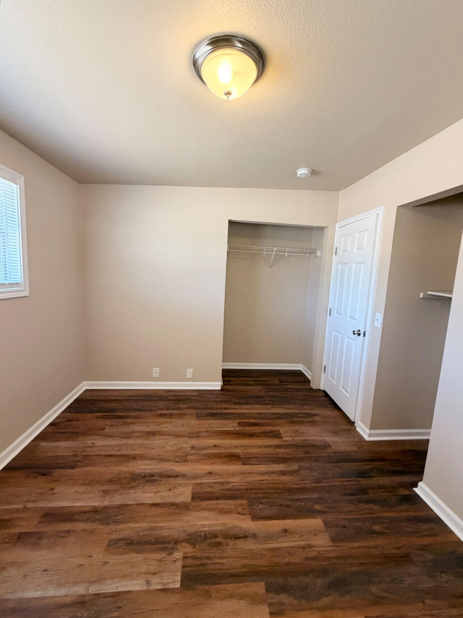 2301 49th Street Lubbock, TX 79412 - Photo 11 of 18 a view of an empty room with wooden floor and a window