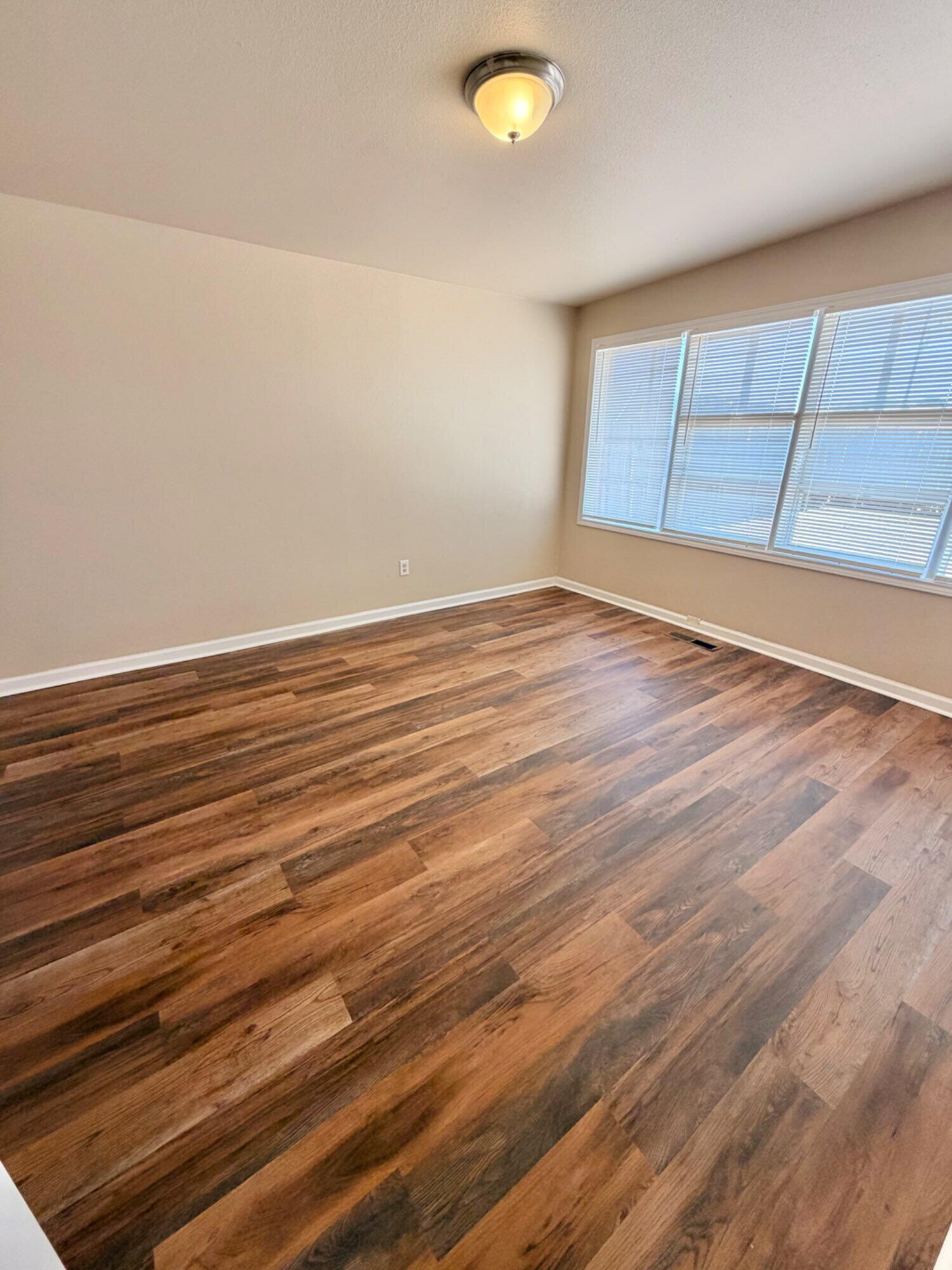 2301 49th Street Lubbock, TX 79412 - Photo 2 of 18 an empty room with wooden floor and windows