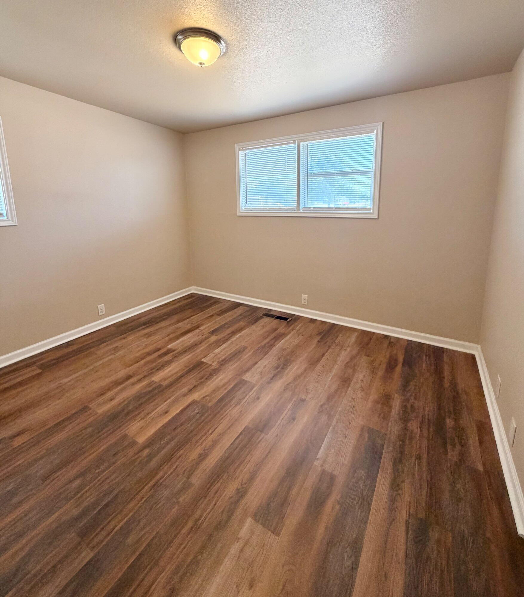 2301 49th Street Lubbock, TX 79412 - Photo 10 of 18 a view of an empty room with wooden floor and a window