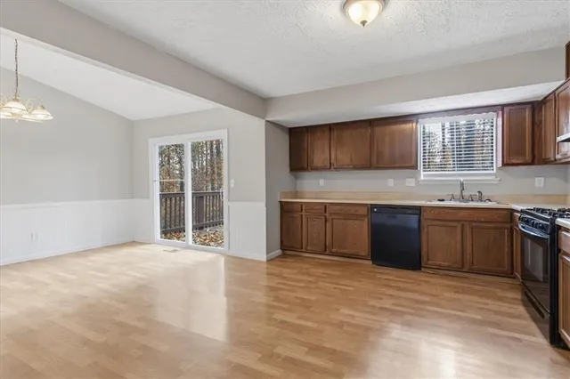 a large kitchen with stainless steel appliances granite countertop a stove a sink dishwasher and a refrigerator