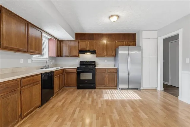 a kitchen with granite countertop a refrigerator and a sink