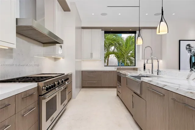 a large white kitchen with a sink and cabinets
