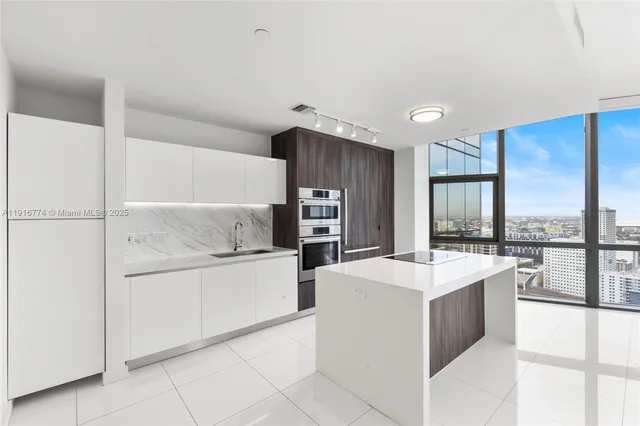 a kitchen with stainless steel appliances a sink and a refrigerator