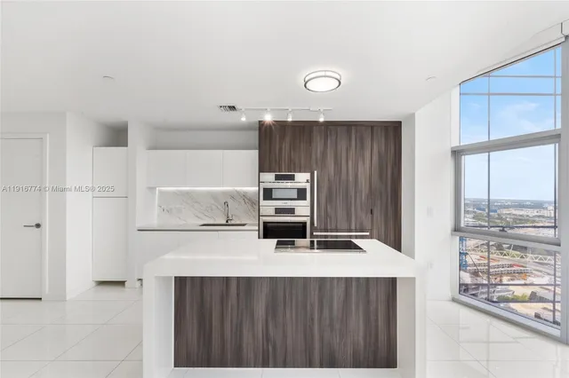 a kitchen with kitchen island a stove a microwave and a refrigerator