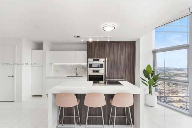 a kitchen with granite countertop a table chairs stove and cabinets