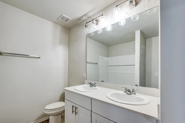 a bathroom with a sink toilet and mirror