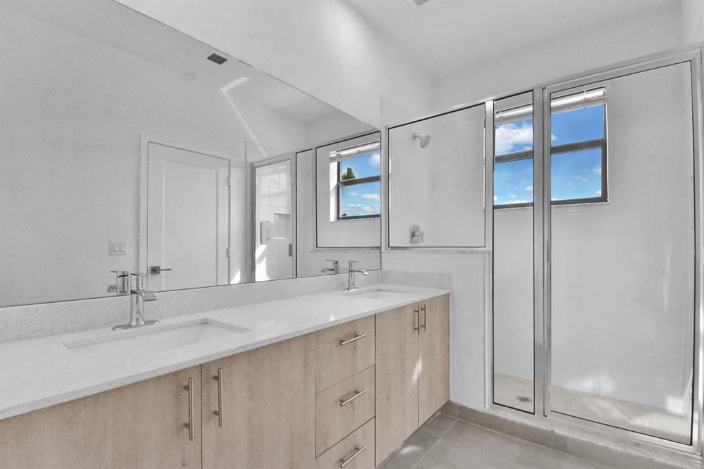 4083 Sunset Way Pompano Beach, FL 33069 - Photo 11 of 34 a bathroom with a double vanity sink and a mirror