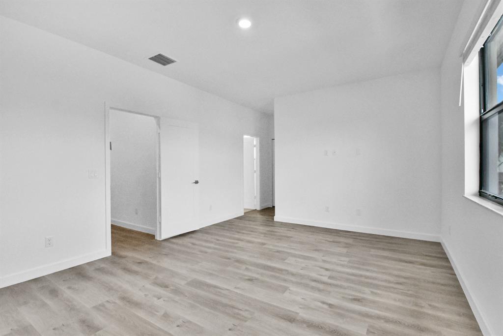 4083 Sunset Way Pompano Beach, FL 33069 - Photo 12 of 34 a view of an empty room with wooden floor and a window