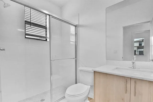 a bathroom with a sink a toilet and shower