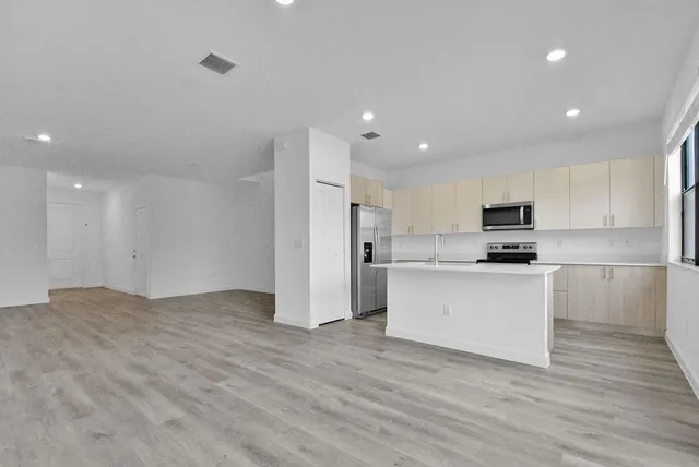 a view of kitchen with granite countertop stainless steel appliances refrigerator and microwave