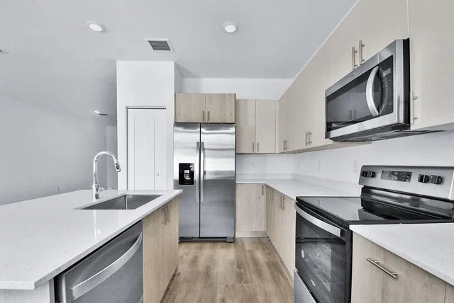 a kitchen with kitchen island a sink appliances and cabinets