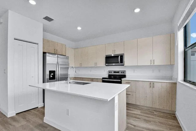 a kitchen with stainless steel appliances a refrigerator stove microwave and sink