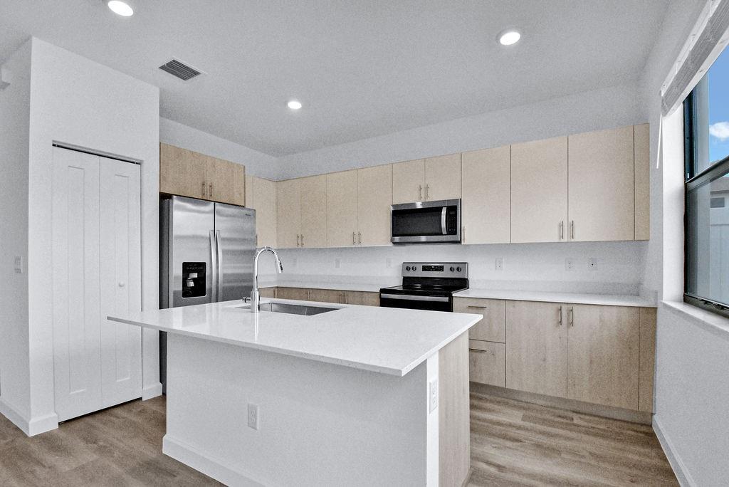 4083 Sunset Way Pompano Beach, FL 33069 - Photo 6 of 34 a kitchen with stainless steel appliances a refrigerator stove microwave and sink