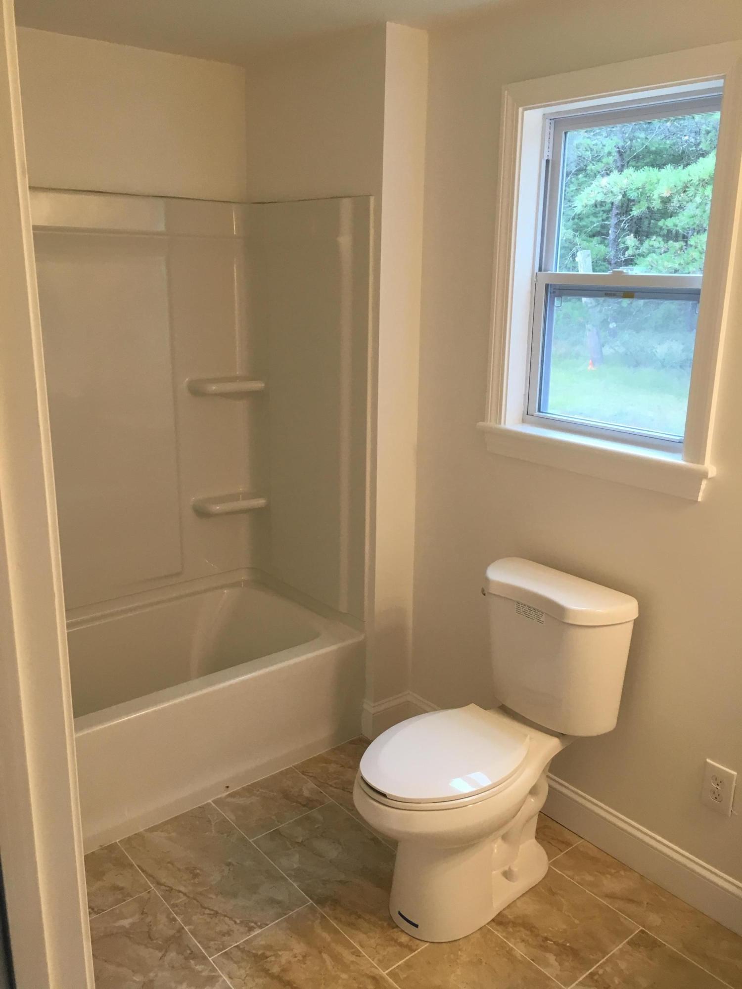18 Seawood Road Wareham, MA 02571 - Photo 7 of 13 a white toilet sitting next to a bath tub