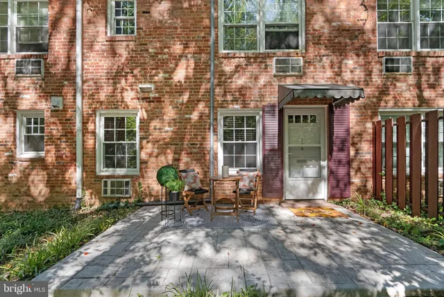 a view of brick building with a bench in front of building