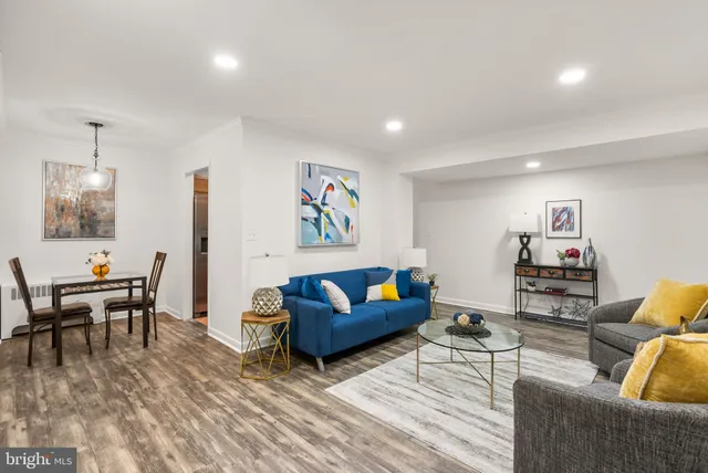a living room with furniture and a wooden floor