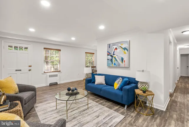 a living room with furniture and a wooden floor