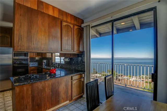 a kitchen with stainless steel appliances granite countertop a refrigerator a stove and a wooden cabinets