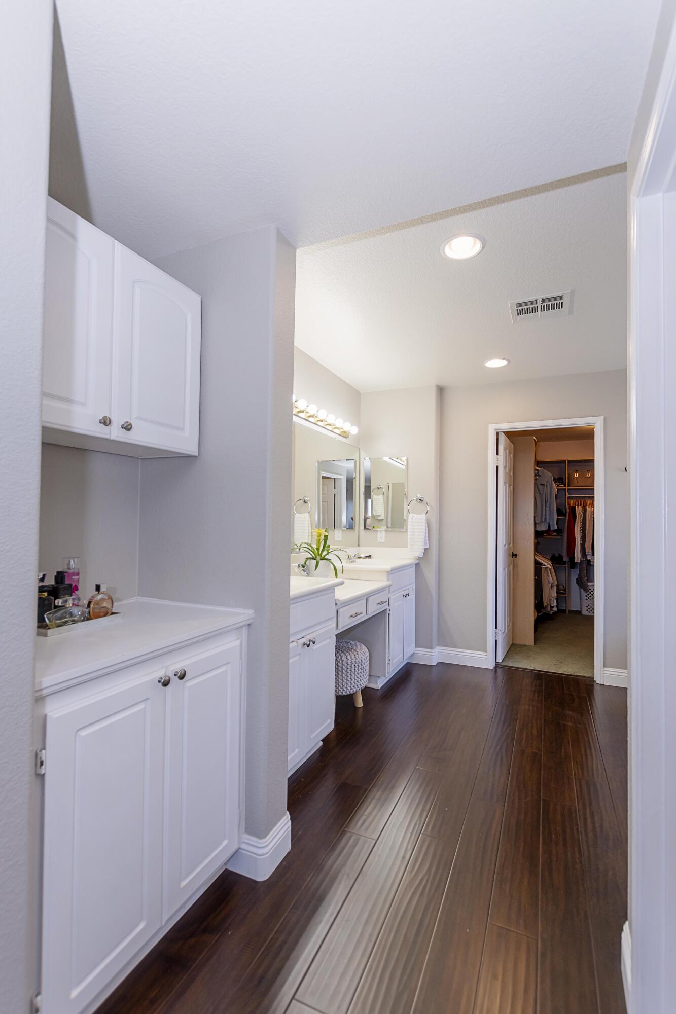12602 Mango Lane Riverside, CA 92503 - Photo 54 of 65 a kitchen with white cabinets and wooden floor