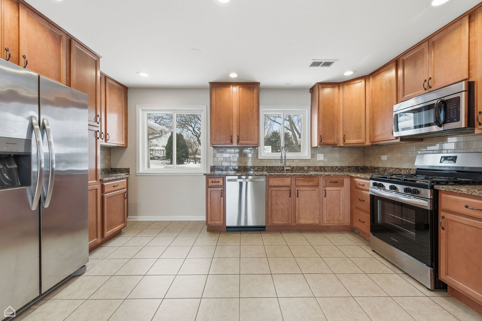 1081 Pinehurst Lane Schaumburg, IL 60193 - Photo 4 of 26 a kitchen with stainless steel appliances granite countertop a stove a sink dishwasher a refrigerator and cabinets with wooden floor