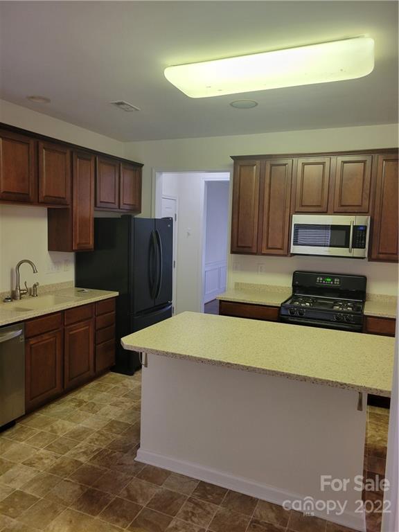 2449 Smith Cove Road Denver, NC 28037 - Photo 9 of 18 a kitchen with wooden cabinets and stainless steel appliances
