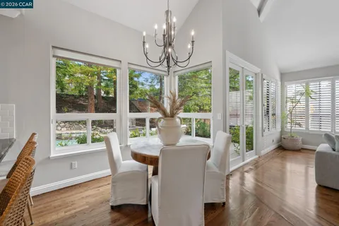 a view of a dining room with furniture large windows and wooden floor