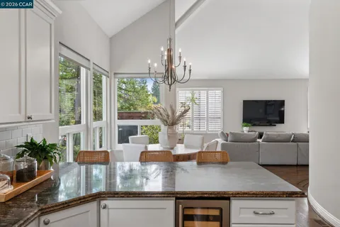 a kitchen with granite countertop a stove and a white cabinets