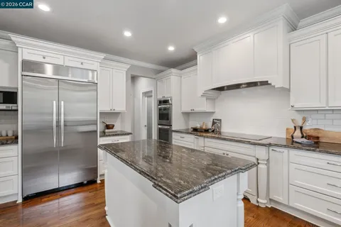 a kitchen with kitchen island a counter top space cabinets and stainless steel appliances