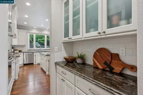 a kitchen with granite countertop a stove a sink and a refrigerator