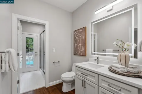 a bathroom with a granite countertop sink a toilet and a mirror