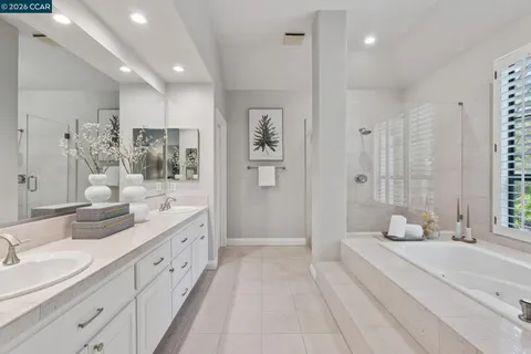 a spacious bathroom with double vanity sinks a shower and a bathtub