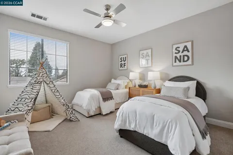 a spacious bedroom with two bed and a window