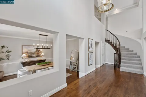 a view of front door with hallway and wooden floor