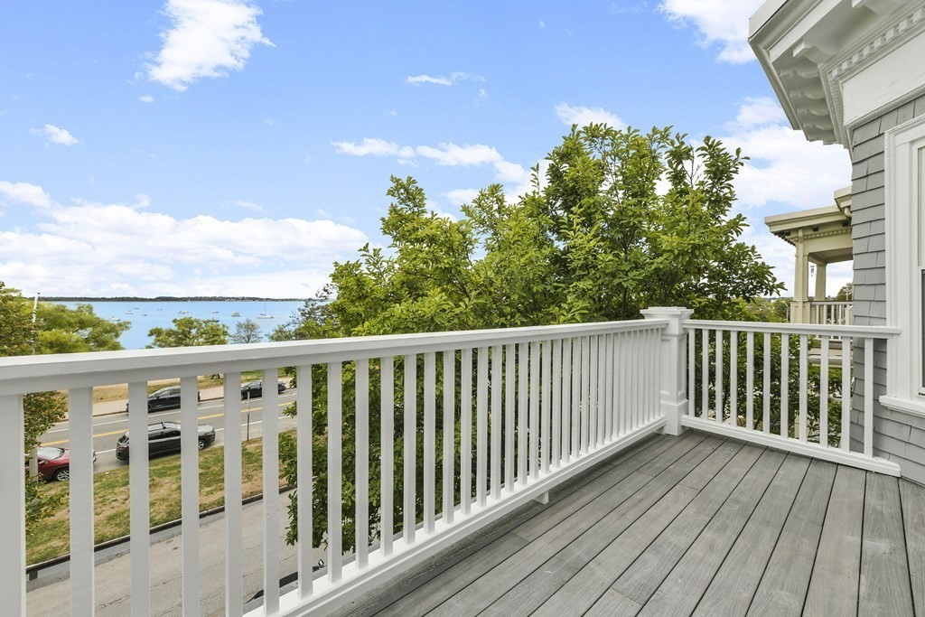 a balcony with wooden floor and city view