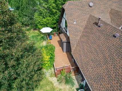 an aerial view of residential houses with outdoor space and trees